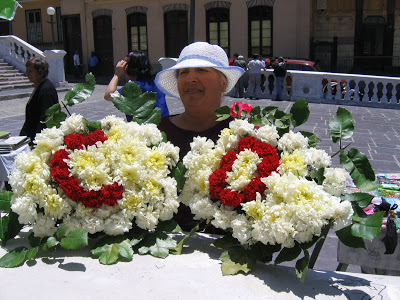 Mujer con sombrero blanco sosteniendo un arreglo floral con letras