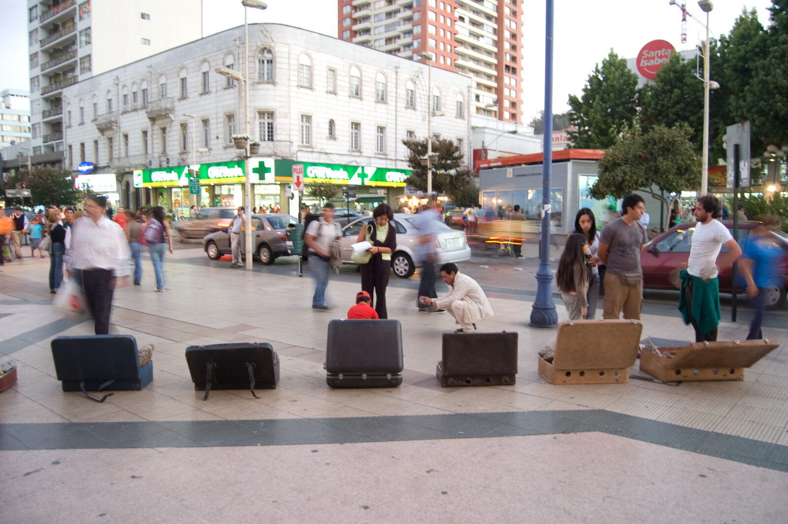 Maletas abiertas con escombros dispuestas en la plaza María Luisa Bombal, Viña del Mar, de día