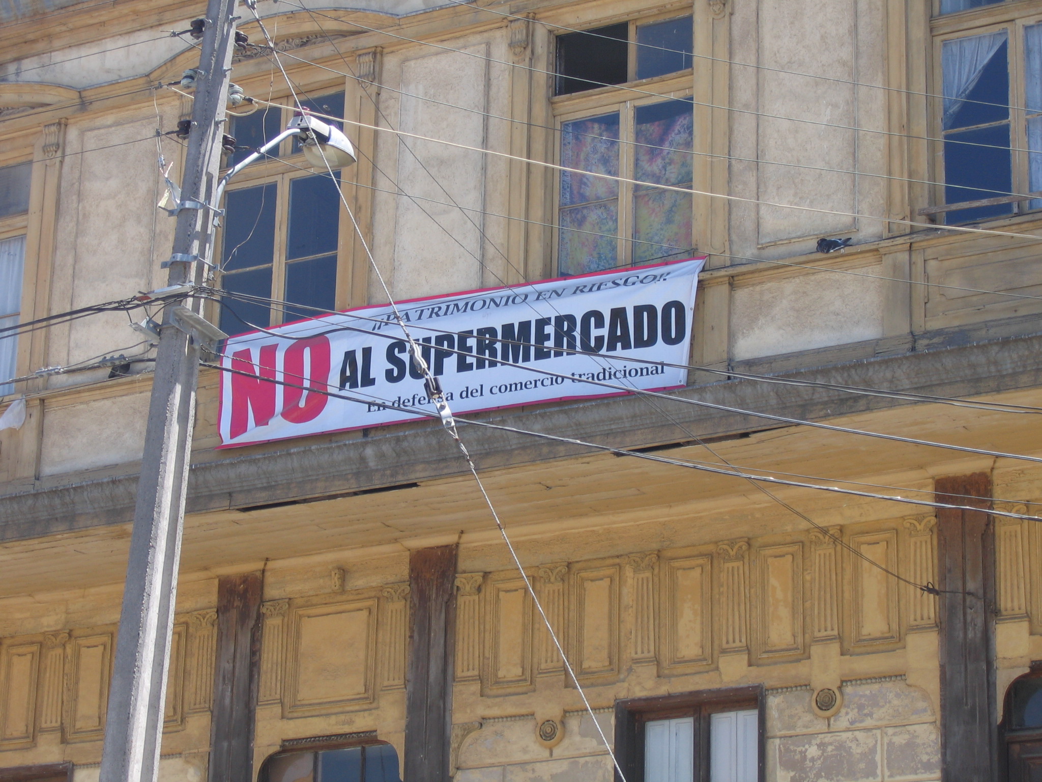 Pancarta «NO AL SUPERMERCADO, Patrimonio en Riesgo» en la fachada de un edificio patrimonial, Valparaíso