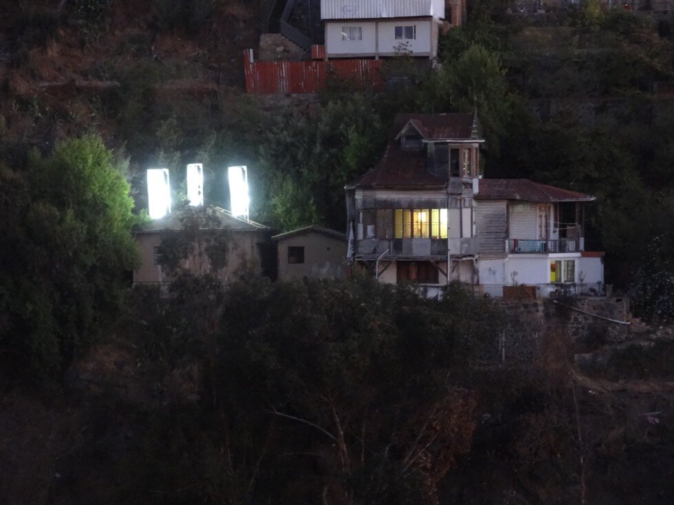 La Casa de Atrás, acercamiento a la vivienda con las torres encendidas al atardecer