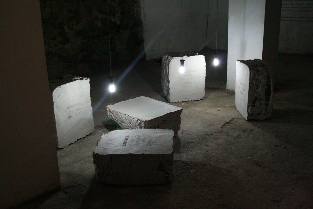 Sala de galería de El Séptimo Peldaño con bloques de yeso inscritos y caja de luz