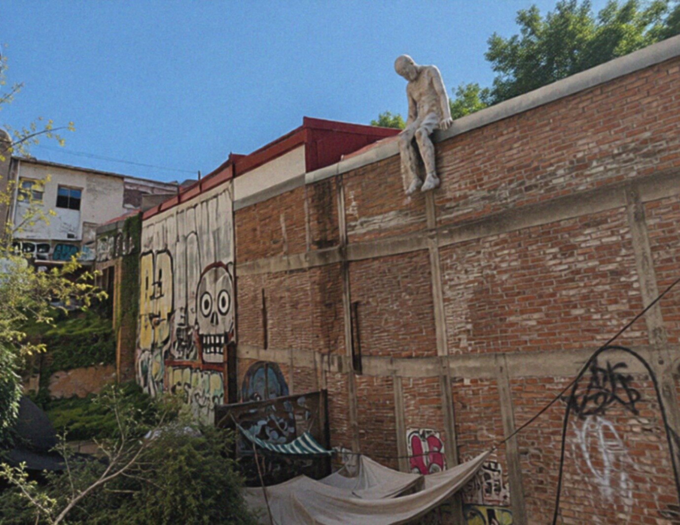 Fotomontaje de cerca de El Nadador Nº 5 sobre el muro de ladrillo con grafiti de calavera, pasaje Gálvez, Cerro Concepción