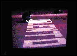 Registro en video de franjas de pintura sobre el pavimento, visto en una pantalla de televisor