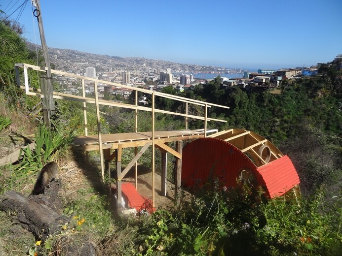 El Jardín de las Delicias, pasarela de madera y estructura roja, con vista a la bahía de Valparaíso