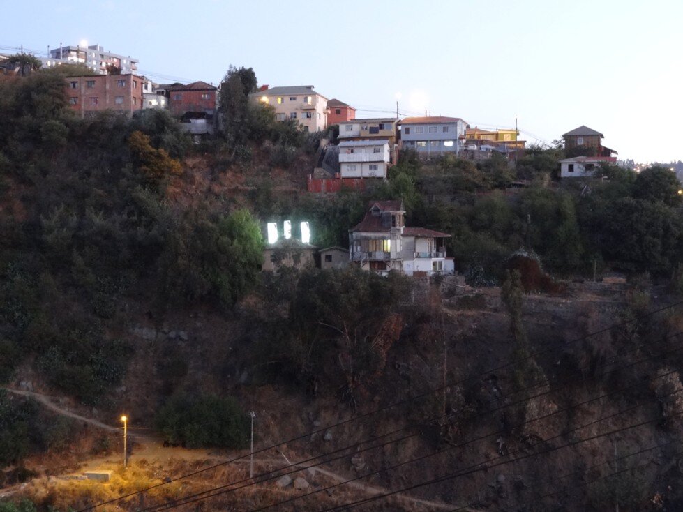 La Casa de Atrás, vista del cerro al atardecer con las torres encendidas
